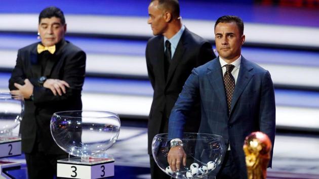 Fabio Cannavaro prepares to pull a team out during the draw as Cafu and Diego Maradona look on. (REUTERS) Fabio Cannavaro prepares to pull a team out during the draw as Cafu and Diego Maradona look on. (REUTERS)
