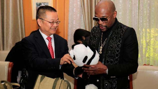 Floyd Mayweather (R) receives a stuffed panda toy during an adoption ceremony in China. (AFP) Floyd Mayweather (R) receives a stuffed panda toy during an adoption ceremony in China. (AFP)