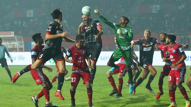 Subrata Paul (centre) of Jamshedpur FC fists away a ball during the match against ATK at the JRD Tata Sports Complex stadium in Jamshedpur on Friday.(ISL / SPORTZPICS)