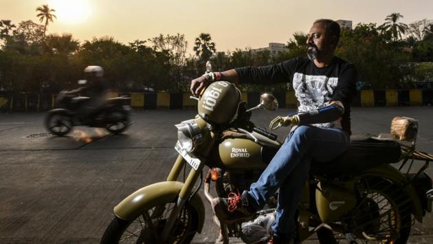 Mahendra Pitale with his bike at Versova, Mumbai. Pitale lost his left hand in the blast at Jogeshwari station in 2006 in Mumbai. Currently employed with the railways, Pitale now rides a Royal Enfield Bullet for various causes using his artificial arm. He joined the bullet club and started cross-country tours, spreading awareness about organ donation and cancer. He also finds time to counsel those impaired by accidents and disease. (Kunal Patil / HT Photo) 