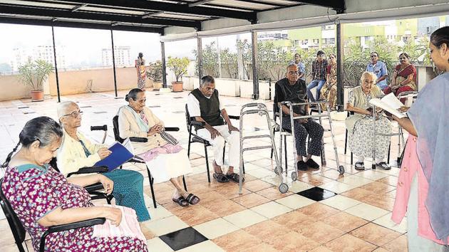 A caregiver engaging the elderly in a book reading activity at Athashree Astha care unit, an assisted-living retirement home situated in Pashan, Pune.(Ravindra Joshi/HT PHOTO)