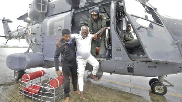 A fisherman who was stranded in the Arabian Sea is escorted from an Indian Navy helicopter after being rescued in Thiruvananthapuram, Kerala on December 01, 2017. At least 200 fishermen marooned at sea were rescued by a joint operation carried out by Navy, Air Force and Coast Guard. A Japanese cargo ship also rescued 60 persons and later handed them to the Coast Guard. (AP) 