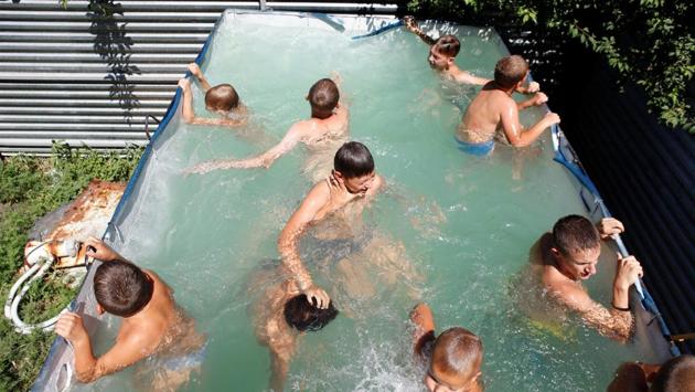 "Patriot" club members exercise in a pool during a visit to the "Russian Knights" base. Over the summer, up to 600 teenaged boys and girls train here. (Eduard Korniyenko / REUTERS) "Patriot" club members exercise in a pool during a visit to the "Russian Knights" base. Over the summer, up to 600 teenaged boys and girls train here. (Eduard Korniyenko / REUTERS)