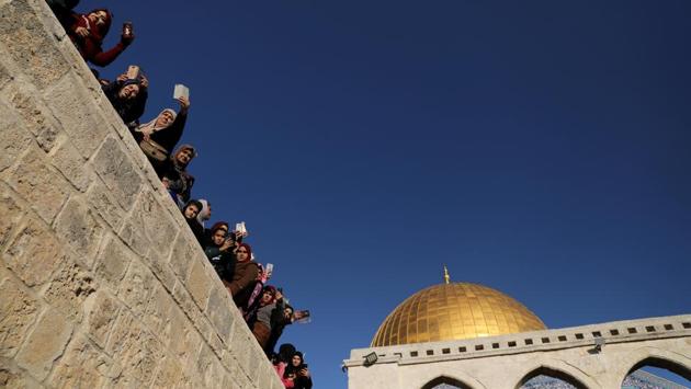 People look on as scouts march and play music in celebration of Mawlid al-Nabi in front of the Dome of the Rock on the compound known to Muslims as Noble Sanctuary and to Jews as Temple Mount, on November 30, 2017 in Jerusalem's Old City. (Ammar Awad / REUTERS)