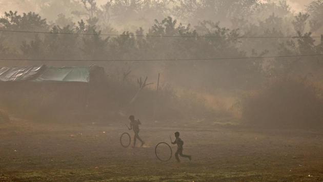 Young boys seen hoop rolling with rubber tyres on the banks of the Yamuna river on a smoggy morning in New Delhi, on November 30, 2017. (Saumya Khandelwal / REUTERS)