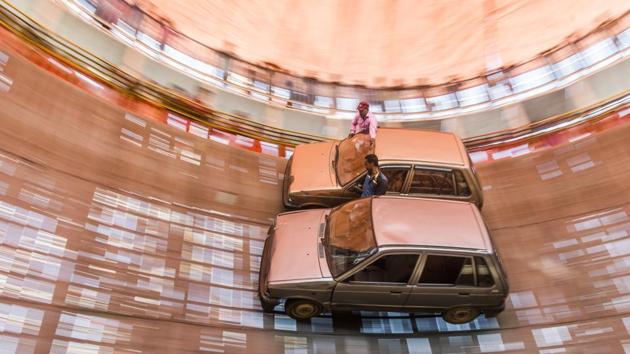 Riders Nizam Ansari and Deepak Nayak perform a routine with a car inside a ‘well of death’ during the Sonpur mela which ended this week in Bihar. (Pratik Chorge / HT Photo)