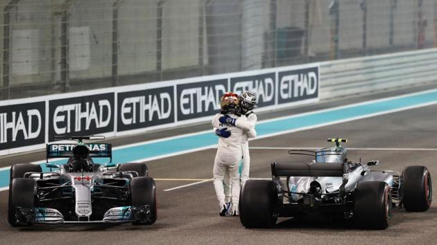 Mercedes' British driver Lewis Hamilton (front) celebrates with his teammate Finnish driver Valtteri Bottas at the end of the Abu Dhabi Formula One Grand Prix on November 26, 2017 at the Yas Marina circuit in Abu Dhabi, United Arab Emirates. (Karim Sahib / AFP)