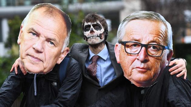 Activists dressed as European Commission President Jean-Claude Juncker (R), EU Commissioner in charge of Health and Food safety Vytenis Andriukaitis (L) and with face painted with a skull enact a tug-of-war against EU citizens during an action calling for the EU Comission to vote against the licence renewal of the chemical glyphosate in front of the European Commission headquarters on November 27, 2017 in Brussels, Belgium. (Emmanuel DunandAFP)