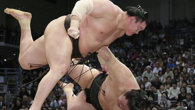 Yokozuna Hakuho of Mongolia (top) slams Goeido of Japan during their bout on the final day of the 15-day Kyushu Grand Sumo Tournament on November 26, 2017 in Fukuoka, Japan . Mongolian grand champion Hakuho won the latest sumo tournament on November 25 as Japan's national sport continued to draw media attention after another top wrestler faced a police probe into an alleged assault. (JiJi Press / AFP)