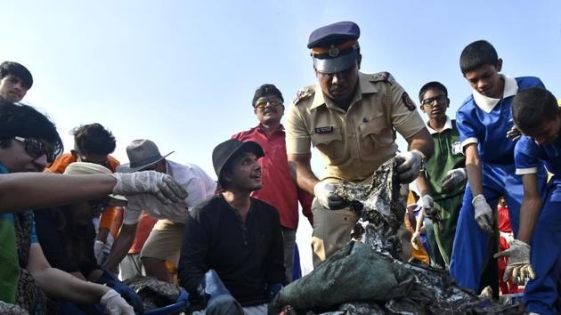 Afroz Shah (in black) clears Versova beach of trash, accompanied by students, policemen and civic officials on Saturday. (Shashi S Kashyap/ HT) Afroz Shah (in black) clears Versova beach of trash, accompanied by students, policemen and civic officials on Saturday. (Shashi S Kashyap/ HT)