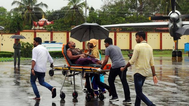 Officials carry a stranded fisherman, rescued by naval and air force helicopters from the Ockhi cyclone, at Thiruvananthpuram airport on Friday.(AFP)
