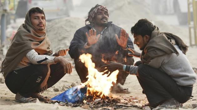 People warm themselves around a fire on a winter morning in New Delhi on November 23.(Raj K Raj/HT PHOTO)