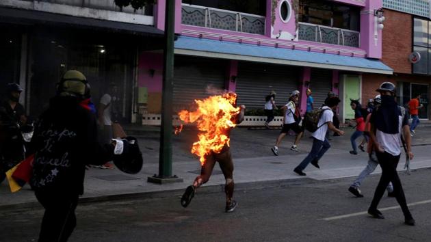 A man accused of stealing was set on fire during a rally against President Nicolas Maduro in Caracas, Venezuela, May 20, 2017. Guns appeared on the streets, and on several occasions security officials were caught on camera firing directly at demonstrators. Police were targeted with homemade explosives. Opposition supporters burned one man alive. (Marco Bello / REUTERS) A man accused of stealing was set on fire during a rally against President Nicolas Maduro in Caracas, Venezuela, May 20, 2017. Guns appeared on the streets, and on several occasions security officials were caught on camera firing directly at demonstrators. Police were targeted with homemade explosives. Opposition supporters burned one man alive. (Marco Bello / REUTERS)