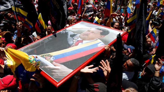Supporters of President Nicolas Maduro demonstrate with a picture of Hugo Chavez during the National Constituent Assembly's first session, in Caracas, Venezuela on August 4, 2017. By the end of July, many opposition supporters feared for their lives and protest numbers dwindled. Maduro said he was defeating a US-backed coup and authorities held an election, which the opposition boycotted, for an all-powerful Constituent Assembly charged with imposing order on the country. (Carlos Garcia Rawlins / REUTERS) Supporters of President Nicolas Maduro demonstrate with a picture of Hugo Chavez during the National Constituent Assembly's first session, in Caracas, Venezuela on August 4, 2017. By the end of July, many opposition supporters feared for their lives and protest numbers dwindled. Maduro said he was defeating a US-backed coup and authorities held an election, which the opposition boycotted, for an all-powerful Constituent Assembly charged with imposing order on the country. (Carlos Garcia Rawlins / REUTERS)