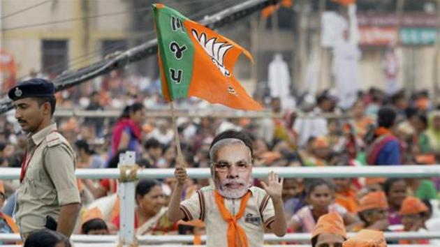 A BJP supporter wears mask of Prime Minister Narendra Modi during his election campaign rally for the state assembly elections, in Surendranagar. (PTI Photo) A BJP supporter wears mask of Prime Minister Narendra Modi during his election campaign rally for the state assembly elections, in Surendranagar. (PTI Photo)