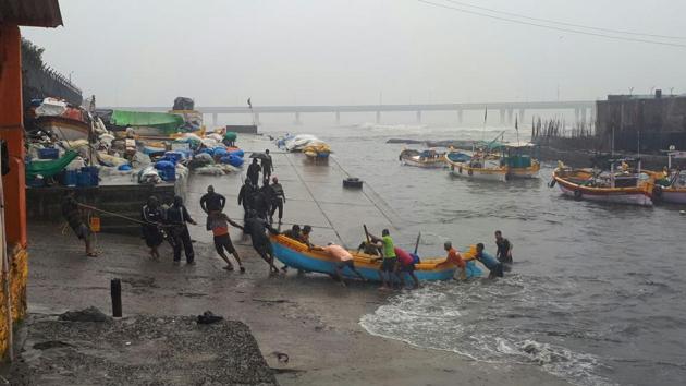 Fishermen pull their boats out of the sea in Worli. (Bhushan Koyande/HT)