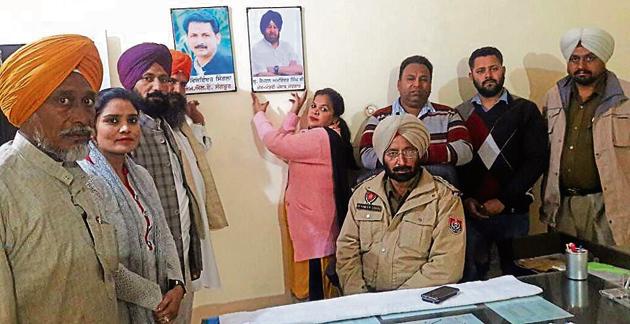 Punjab Youth Congress general secretary Poonam Kangra and other party workers installing portraits of CM Capt Amarinder Singh and local MLA Vijay Inder Singla at the Sangrur (sadar) police station as SHO Davinder Singh sits in the chair. The photo was emailed to media house by her seeking coverage.(HT Photo)