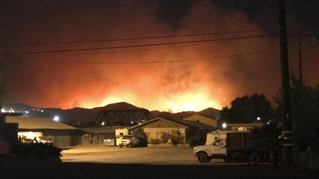 Flames from a wildfire loom up over a neighbourhood in Santa Paula, Calfornia, Monday. (AP Photo)