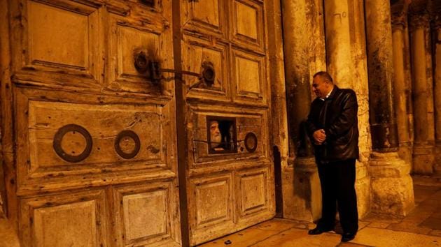 Adeeb Joudeh (R), looks at a priest as he peers through an opening in the church doors as they prepare to open it, in Jerusalem's Old City. “I started learning this when I was eight years old. It’s handed down from father to son,” said Joudeh. “I have been doing this for 30 years and I feel that the Church of the Holy Sepulchre is my second home.” (Ronen Zvulun / REUTERS) Adeeb Joudeh (R), looks at a priest as he peers through an opening in the church doors as they prepare to open it, in Jerusalem's Old City. “I started learning this when I was eight years old. It’s handed down from father to son,” said Joudeh. “I have been doing this for 30 years and I feel that the Church of the Holy Sepulchre is my second home.” (Ronen Zvulun / REUTERS)