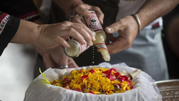 At another funeral a couple covers the bones and ashes of a pet dog with sacred oil, before releasing the remains in the Chaopraya river in Bangkok. According to Buddhist belief, merit garnered in each life eventually leads to nirvana -- the state of non-suffering. (Lillian Suwanrumpha / AFP)