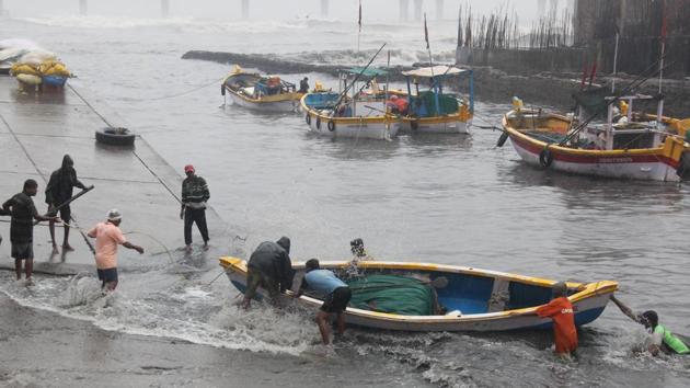 Fisherman pull their boats out of the sea at Worli on Tuesday. (Bhushan Koyande/HT) Fisherman pull their boats out of the sea at Worli on Tuesday. (Bhushan Koyande/HT)