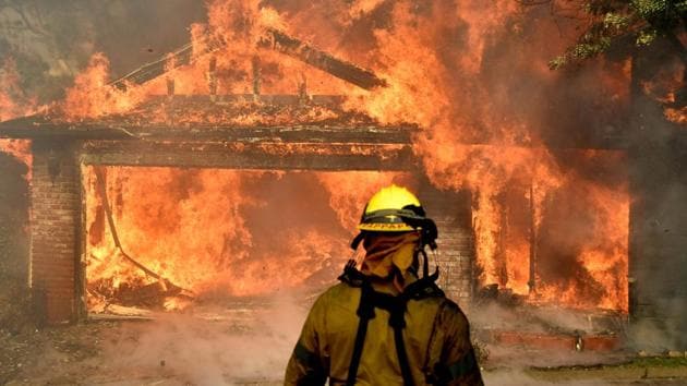 Firefighters battle to save one of many homes burning in an early-morning Creek Fire that broke out in the Kagel Canyon area in the San Fernando Valley north of Los Angeles, in Sylmar, California, US. (Reuters)
