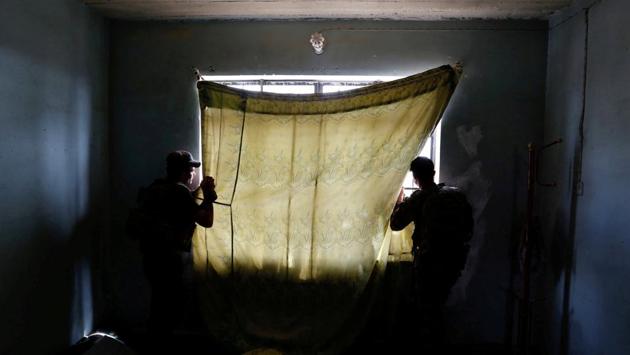 Members of the Iraqi Counter Terrorism Service (CTS) forces look at the positions of Islamic State militants during clashes in western Mosul, in May 2017. The people who once lived there departed quickly, leaving clothes and toys scattered across the floor. The next inhabitants left hollow shell casings. (Danish Siddiqui / REUTERS)