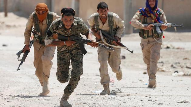 Kurdish fighters from the People’s Protection Units (YPG) run to cover in Raqqa, Syria. In one village, a single IS sniper hunkered down in a house held up hundreds of Kurdish fighters, US special forces and 40 vehicles. Eventually, his rifle went silent after three air strikes on the house. IS fighters were experts at suicide bombings and assembling homemade bombs. Many houses were booby-trapped. Iraqi military commanders had to factor these perils into their warplans. (Goran Tomasevic / REUTERS)