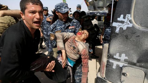Iraqi Federal Police and a man carry a civilian, injured while opening a booby-trapped shop in Tayaran district. After months of gruelling fighting, Iraqi forces finally attained the outskirts of Mosul, but any celebrations were premature. Booby traps and car bombs littered dusty roads. A Mosul resident explained that his child no longer flinched at explosions because many, including the young, had grown numb to the daily bloodshed. (Zohra Bensemra / REUTERS)