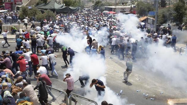Palestinians evade tear gas thrown by Israeli police outside the Old City on July 21, 2017. Israeli security officials say they are monitoring the situation for all scenarios. Much of the violence between Israel and the Palestinians over the past 20 years has been connected to the holy city. More recently, a wave of Palestinian stabbings erupted in late 2015 in part due to growing numbers of Jewish nationalists heading to the Temple Mount. (Mahmoud Illean / AP) 