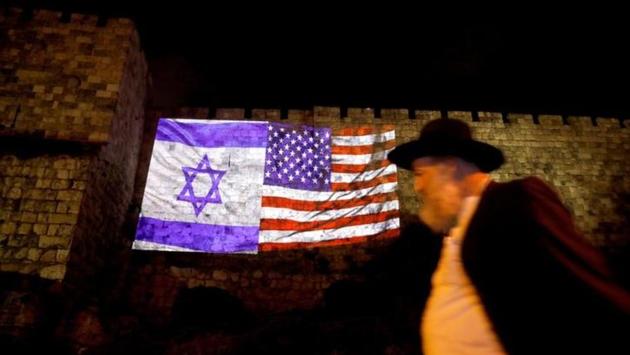 An Israeli man passes the Israeli flag and an American one projected on a part of the walls surrounding Jerusalem's Old City on December 6, 2017. Trump’s recognition of Jerusalem isolates the United States on one of the world’s most sensitive diplomatic issues. It drew a storm of criticism from Arab and European leaders, including some of America’s closest allies. (Ronen Zvulun / REUTERS) An Israeli man passes the Israeli flag and an American one projected on a part of the walls surrounding Jerusalem's Old City on December 6, 2017. Trump’s recognition of Jerusalem isolates the United States on one of the world’s most sensitive diplomatic issues. It drew a storm of criticism from Arab and European leaders, including some of America’s closest allies. (Ronen Zvulun / REUTERS)