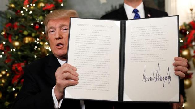 US President Donald Trump holds up the proclamation that announces the United States recognising Jerusalem as the capital of Israel and moving its embassy there, during an address from the White House in Washington.(Reuters)