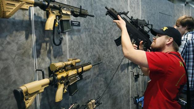 Nolan Hammer looks at a gun at the Heckler & Koch booth at the Shooting, Hunting and Outdoor Trade Show in Las Vegas. Backers of an expanded gun background check ballot measure approved by Nevada voters in 2016 are arguing that the Nevada governor and attorney general are wrong to say they can't enforce the law. (AP File Photo) Nolan Hammer looks at a gun at the Heckler & Koch booth at the Shooting, Hunting and Outdoor Trade Show in Las Vegas. Backers of an expanded gun background check ballot measure approved by Nevada voters in 2016 are arguing that the Nevada governor and attorney general are wrong to say they can't enforce the law. (AP File Photo)