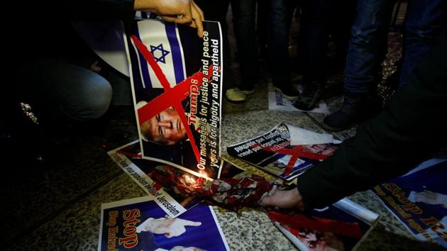 Palestinian demonstrators burn posters of the US president in Bethlehem in protest of the declaration on December 6, 2017. Palestinian president, Mahmoud Abbas, a veteran of the peace process, said bitterly that the United States had effectively scrapped it. Saeb Erekat, the chief Palestinian negotiator, called for the abandonment of a two-state solution altogether. (Musa Al Shaer / AFP) Palestinian demonstrators burn posters of the US president in Bethlehem in protest of the declaration on December 6, 2017. Palestinian president, Mahmoud Abbas, a veteran of the peace process, said bitterly that the United States had effectively scrapped it. Saeb Erekat, the chief Palestinian negotiator, called for the abandonment of a two-state solution altogether. (Musa Al Shaer / AFP)