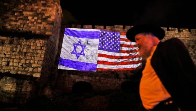 A picture taken on December 6, 2017 shows a giant US flag screened alongside Israel's national flag by the Jerusalem municipality on the walls of the old city.(AFP Photo)