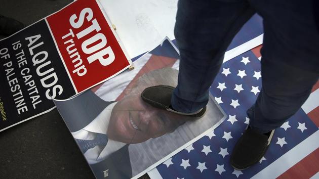 A Palestinian steps on a poster of U.S. President Donald Trump and a representation of the American flag during a protest against the US decision to recognize Jerusalem as Israel's capital, in Gaza City Thursday, December 7.(AP Photo)