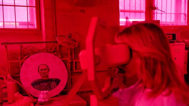 A visitor looks at an immersive installation with a plate depicting Russian president Vladimir Putin as a Roman warrior in the background. The exhibition opened on the day that he announced his bid for a fourth term as Russia’s President. (Maxim Shemetov / REUTERS)