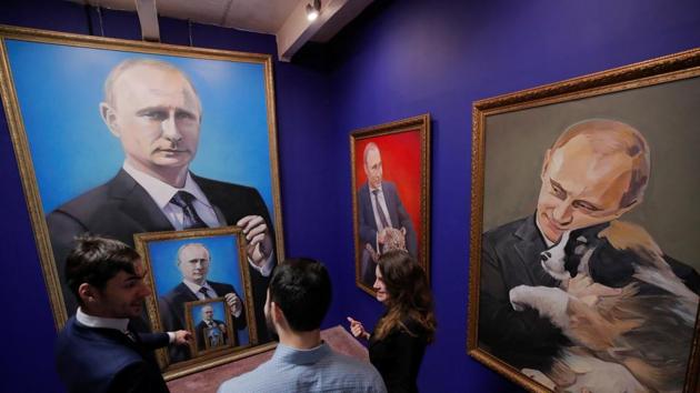 A portrait of Putin, holding a portrait of himself holding a portrait of Putin holding yet another portrait! Put-inception much? (Maxim Shemetov / REUTERS)