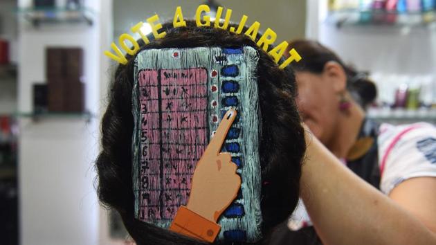 A beautician gives paints 'Electronic Voting Machine' (EVM) on the hair of a girl ahead of Gujarat's legislative assembly election, in Ahmedabad.(AFP Photo)