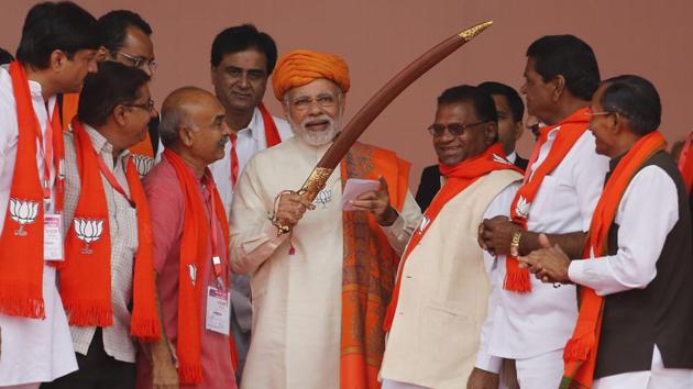 PM Narendra Modi (C) holds a sword presented to him during an election campaign rally at Dhandhuka in Gujarat on Wednesday. (Ajit Solanki / AP) PM Narendra Modi (C) holds a sword presented to him during an election campaign rally at Dhandhuka in Gujarat on Wednesday. (Ajit Solanki / AP)
