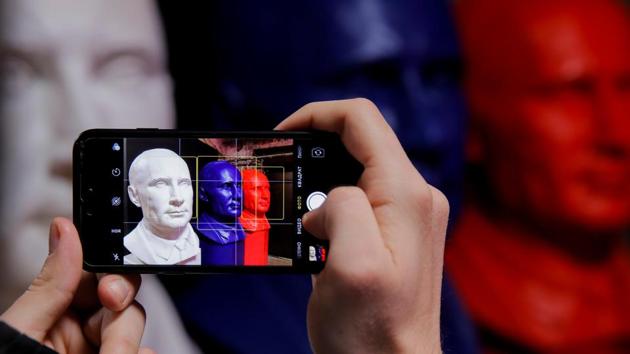 A man takes a picture of busts depicting Russian president Vladimir Putin in the colours of the Russian national flag at the "SUPERPUTIN" exhibition. The former KGB officer has been in power, either as president or prime minister, since 2000. (Maxim Shemetov / REUTERS)