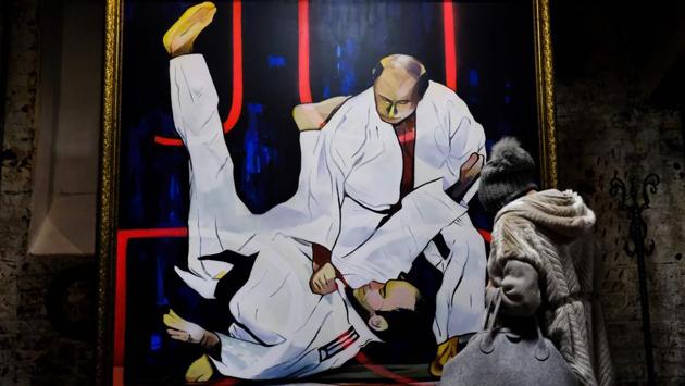 A visitor looks at a painting depicting Russian president Vladimir Putin, a reported black belt, take down an opponent in a Judo match. Putin’s martial arts skills are the stuff of legend and receive extensive coverage within Russian media. (Yuri Kadobnov / AFP)