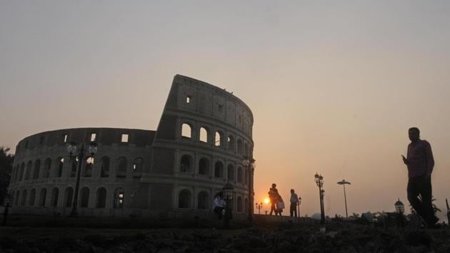 People take a walk along the replica of  the Colosseum in Rome. The artisans have worked rigorously under the guidance of eminent artist Rupchand Kundu, who executed this vast project. The park opened to the public last month.  (Samir Jana / HT Photo) 