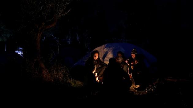 A Syrian family sits around a bonfire at a makeshift camp. Many migrants living on Lesbos were not aware of the deal blocking their journey onwards to northern Europe. According to the island’s mayor, Spyros Galinos, policies have turned the island into “an open prison” and called for protests and strikes against the deal. (Alkis Konstantinidis / REUTERS) A Syrian family sits around a bonfire at a makeshift camp. Many migrants living on Lesbos were not aware of the deal blocking their journey onwards to northern Europe. According to the island’s mayor, Spyros Galinos, policies have turned the island into “an open prison” and called for protests and strikes against the deal. (Alkis Konstantinidis / REUTERS)