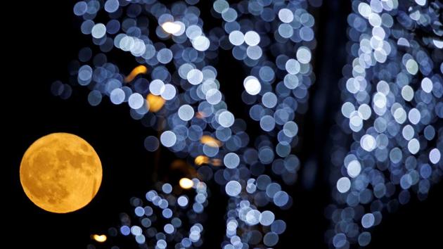 The full moon is pictured behind Christmas lights in Marseille, France on December 3, 2017. (Jean-Paul Pelissier / REUTERS) 