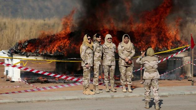 Members of the anti narcotics force pose for a picture as drugs are burned during a ceremony in Islamabad, Pakistan on December 5, 2017. (Caren Firouz / REUTERS) 