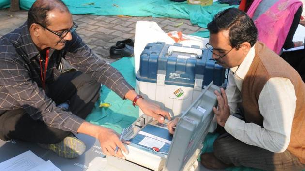 Polling officials checking the electronic voting machines (EVMs) in Surat on Friday on the eve of the first phase of the Gujarat Assembly election.(PTI)