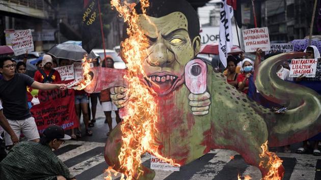 Activists burn a caricature of Philippine President Rodrigo Duterte as a gun-toting tyrannosaurus dinosaur in Manila on December 8, 2017. The demonstrators denounced the government’s war on drugs campaign, the extension of martial law in Mindanao and the crackdown on activists, while calling for Duterte’s ouster from office. (Noel Celis / AFP) 