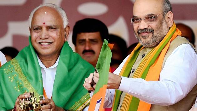 BJP President Amit Shah presenting a party flag and a bullock cart memento to State Unit President BS Yeduyurappa during the launch of party’s 75-day ‘Nava Karnataka Nirmana Parivartan Yatra’ in Bengaluru in November 2017. (PTI File Photo) BJP President Amit Shah presenting a party flag and a bullock cart memento to State Unit President BS Yeduyurappa during the launch of party’s 75-day ‘Nava Karnataka Nirmana Parivartan Yatra’ in Bengaluru in November 2017. (PTI File Photo)