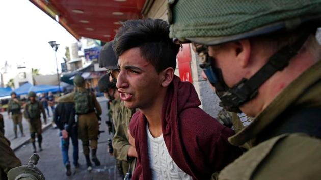 Israelis arrest a Palestinian stone thrower during clashes in the city centre of the West Bank town of Hebron on December 10, 2017. (AFP) Israelis arrest a Palestinian stone thrower during clashes in the city centre of the West Bank town of Hebron on December 10, 2017. (AFP)